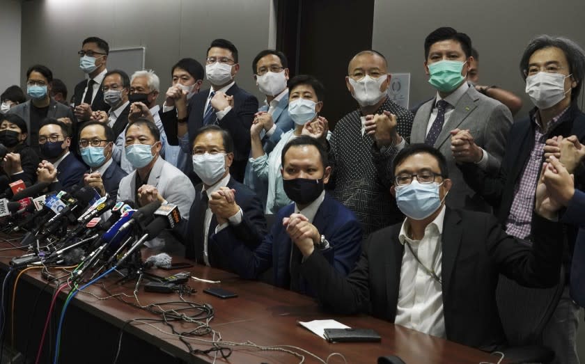 Hong Kong's pro-democracy legislators pose for a photo before a press conference at Legislative Council in Hong Kong, Wednesday, Nov. 11, 2020. Hong Kong's pro-democracy lawmakers announced that they are resigning en masse following a move by the city's government to disqualify four pro-democracy legislators. (AP Photo/Vincent Yu)