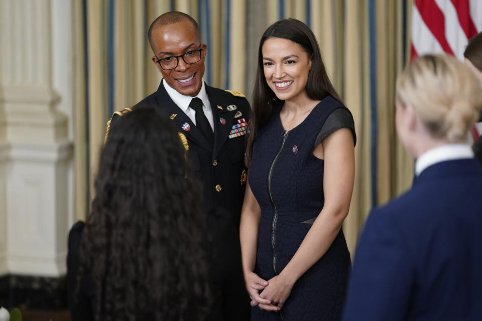 Rep. Alexandria Ocasio-Cortez, D-N.Y., poses for a photo after President Joe Biden signed the Postal Service Reform Act of 2022 in the State Dining Room at the White House in Washington, Wednesday, April 6, 2022. The long-fought postal overhaul has been years in the making. It comes amid widespread complaints about mail service slowdowns. (AP Photo/Susan Walsh)