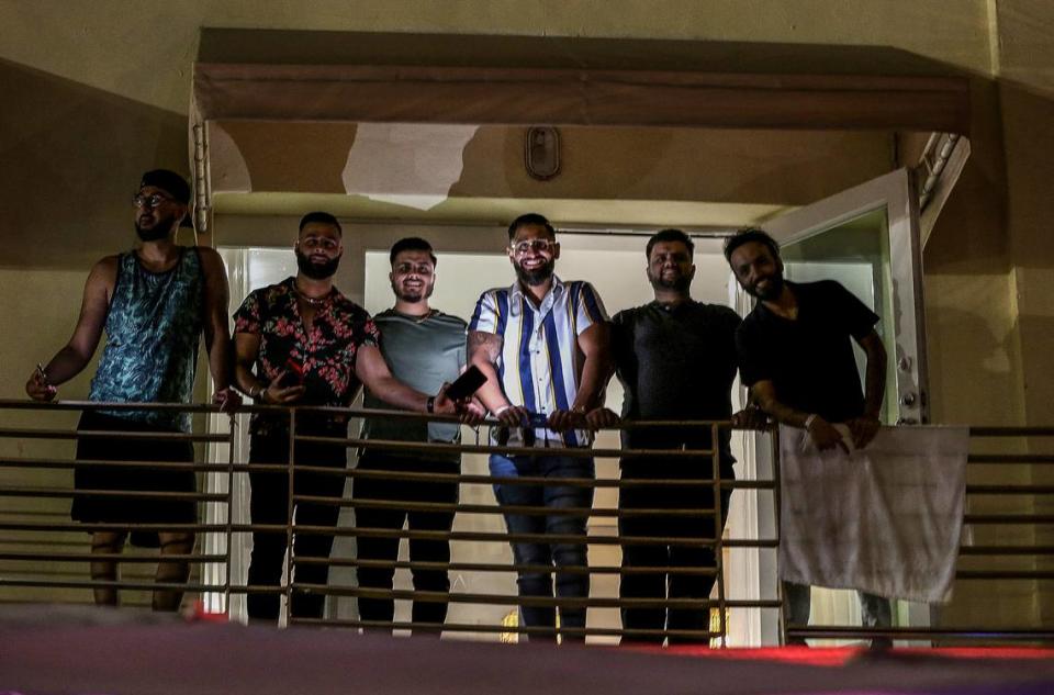 Harp Galsicq​ (third from right) and his friends from Toronto hang out in the balcony of the apartment they rented for his bachelor party in Ocean Drive on Saturday night, March 26, 2022, hours before a midnight curfew, imposed by the City of Miami Beach for the South Beach area, due to two shootings the weekend before, that caused city officials to announce a “state of emergency”.