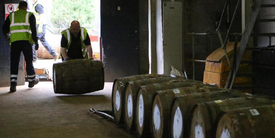 In this photo taken June 30, 2016, a worker rolls in a barrel of whisky at The Macallan distillery in Craigellachie, Scotland. The distillery, famous for its single-malt whisky offers a detailed tour explaining what goes into making the product. (Michelle Locke via AP)