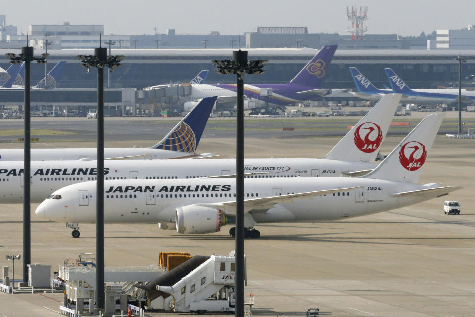 A Japan Airlines Boeing 787 plane, foreground, sits on a tarmac with others at Haneda Airport in Tokyo Friday, April 26, 2013. Japan's transport minister said Friday the government is poised to allow Japanese airlines to resume flying grounded Boeing 787s once they complete installation of systems to reduce fire risk in problematic lithium ion batteries. (AP Photo/Kyodo News) JAPAN OUT, MANDATORY CREDIT, NO SALES IN CHINA, HONG KONG, JAPAN, SOUTH KOREA AND FRANCE