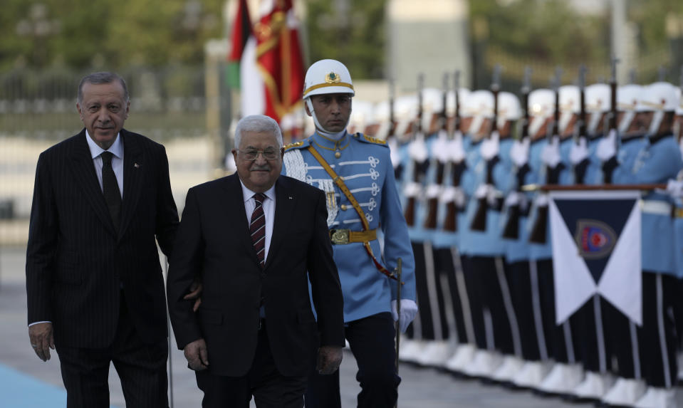 Turkey's President Recep Tayyip Erdogan, left, and Palestinian President Mahmoud Abbas review a military honour guard during a welcome ceremony in Ankara, Turkey, Tuesday, Aug. 23, 2022. Abbas is in Turkey for a two-day state visit. (AP Photo/Burhan Ozbilici)