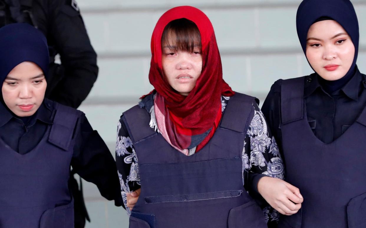 An emotional Doan Thi Huong is escorted by police as she leaves the Shah Alam court - AP