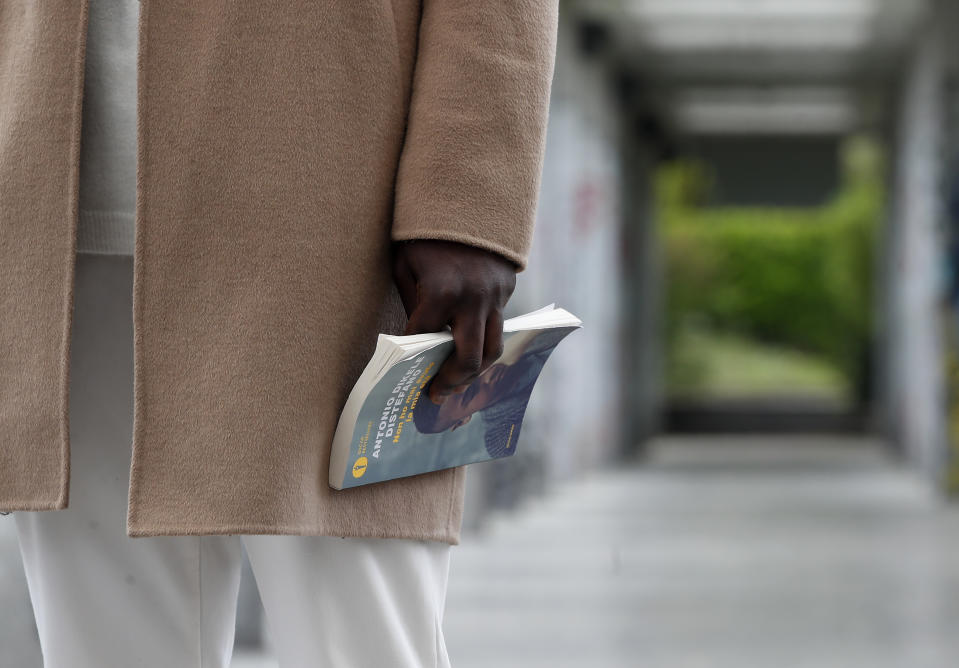 Author and screenwriter Antonio Dikele Distefano holds a book as he talks with the Associated Press in Milan, Italy, Tuesday, April 27, 2021. The Netflix series “Zero,” which premiered globally last month, is the first Italian TV production to feature a predominantly black cast, a bright spot in an otherwise bleak television landscape where the persistent use of racist language and imagery in Italy is sparking new protests. (AP Photo/Antonio Calanni)