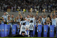 Argentina's Lionel Messi, center, raises the FIFA World Cup trophy during a celebration ceremony for local fans after an international friendly soccer match against Panama in Buenos Aires, Argentina, Thursday, March 23, 2023. (AP Photo/Natacha Pisarenko)