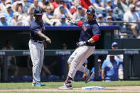 Boston Red Sox third base coach Carlos Febles, left, looks on as J.D. Martinez, right, stops at third base after hitting a triple in the third inning of a baseball game against the Kansas City Royals at Kauffman Stadium in Kansas City, Mo., Sunday, June 20, 2021. (AP Photo/Colin E. Braley)