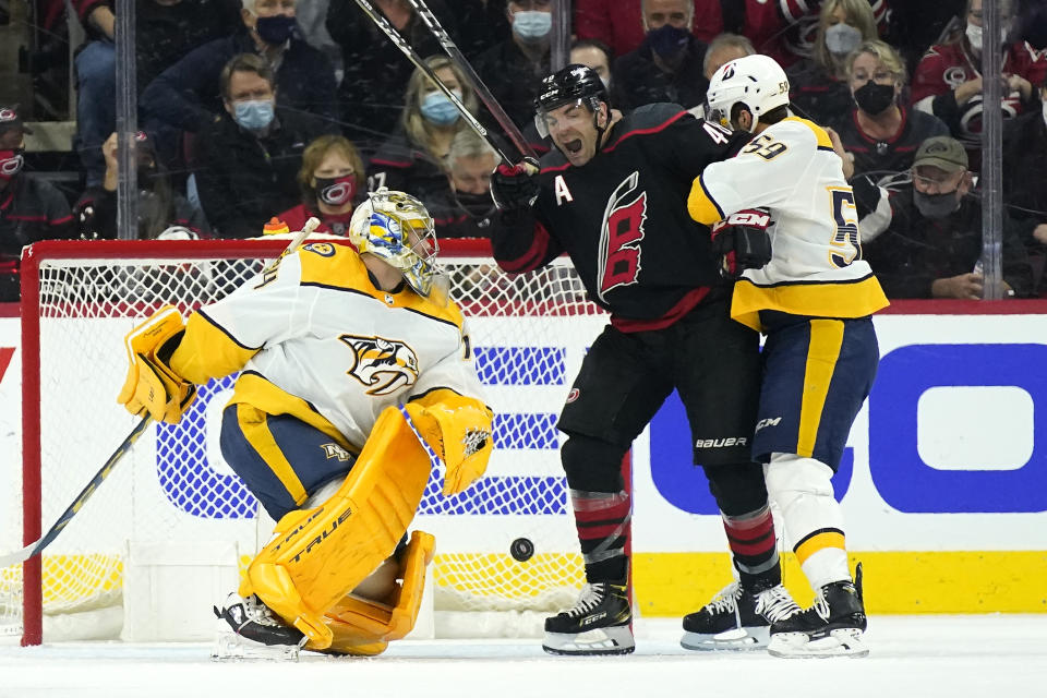 Carolina Hurricanes left wing Jordan Martinook, center, reacts to a goal scored by left wing Teuvo Teravainen (not shown) while Nashville Predators defenseman Roman Josi (59) and goaltender Juuse Saros (74) defend the goal during the first period in Game 1 of an NHL hockey Stanley Cup first-round playoff series in Raleigh, N.C., Monday, May 17, 2021. (AP Photo/Gerry Broome)