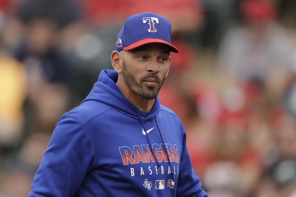 FILE - In this Friday, Feb. 28, 2020, file photo, Texas Rangers manager Chris Woodward walks back to the dugout after making a pitching change during the third inning of a spring training baseball game against the Los Angeles Angels, in Tempe, Ariz. (AP Photo/Charlie Riedel, File)