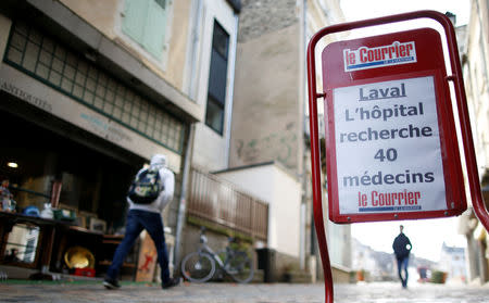 A placard for the local newspaper which reads "Laval hospital is looking for 40 doctors" is seen in a street in Laval, France, November 8, 2018. Picture taken November 8, 2018. REUTERS/Stephane Mahe