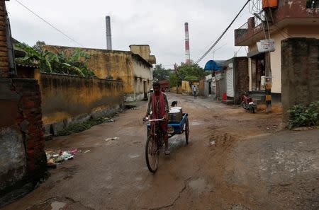 A man rides his trishaw outside a coal-fired power plant in New Delhi, India, July 20, 2017. REUTERS/Adnan Abidi