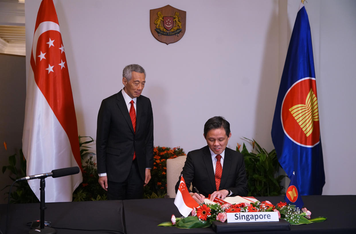 Singapore's Minister for Trade and Industry Chan Chun Sing (right) signing the Regional Comprehensive Economic Partnership trade agreement, with Prime Minister Lee Hsien Loong witnessing the ceremony.