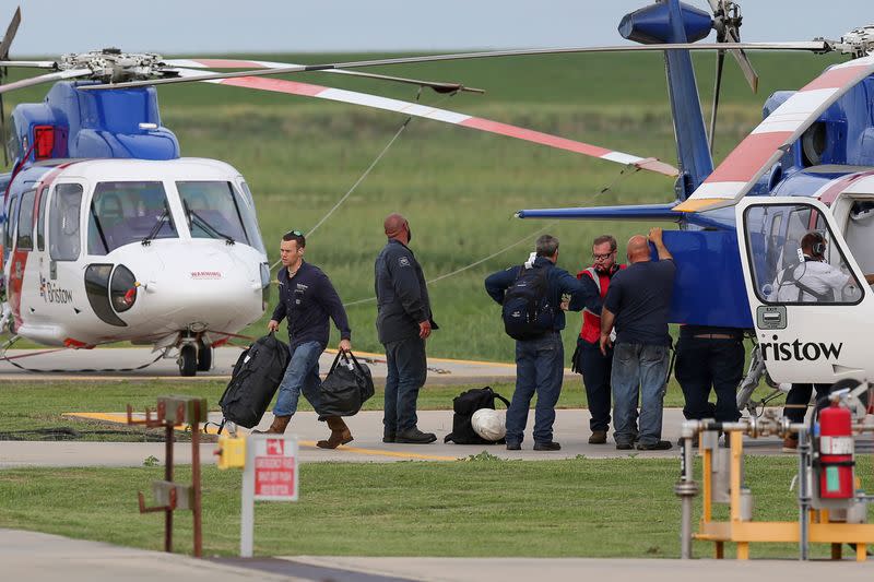 Workers disembark from a helicopter after being evacuated from oil production platforms ahead of Tropical Storm Cristobal, in Galliano