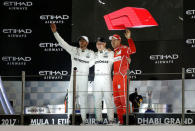 Formula One - Abu Dhabi Grand Prix - Yas Marina circuit, Abu Dhabi, United Arab Emirates - November 26, 2017 Mercedes' Valtteri Bottas (C) celebrates winning the race as Mercedes' Lewis Hamilton (L) celebrates finishing second and Ferrari's Sebastian Vettel (R) celebrates finishing third REUTERS/Ahmed Jadallah