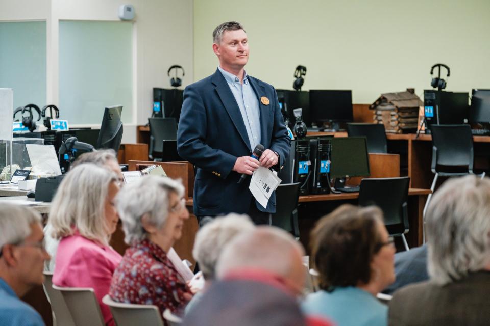 Dover Public Library Director Jim Gill listens to an introduction of former Ohio Gov. Richard Celeste by Sherrel Rieger on Saturday.