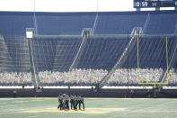 Referees break their meeting before the first half of an NCAA college football game between Michigan and Michigan State, Saturday, Oct. 31, 2020, in Ann Arbor, Mich. (AP Photo/Carlos Osorio)
