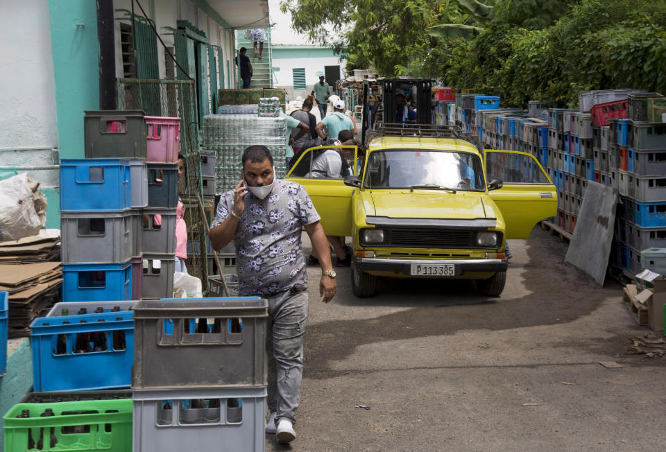 Los clientes ingresan a través de la parte posterior del mercado mayorista Mercabal para cargar su mercancía el jueves 30 de julio de 2020, en La Habana, Cuba. El gobierno está permitiendo que las empresas privadas compren al por mayor por primera vez. (AP Foto/Ismael Francisco)