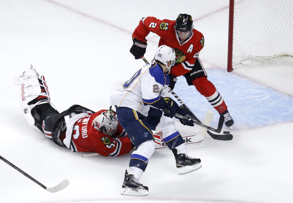 Chicago Blackhawks goalie Corey Crawford, left, tries to keep St. Louis Blues left wing Alexander Steen (20) from getting a shot on goal as defenseman Duncan Keith also defends during the first period in Game 3 of a first-round NHL hockey Stanley Cup playoff series game Monday, April 21, 2014, in Chicago. (AP Photo/Charles Rex Arbogast)