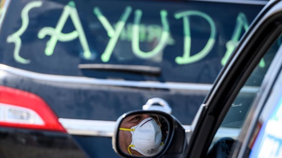 Dos autos, uno de ellos con un cartel que dice "Ayuda"