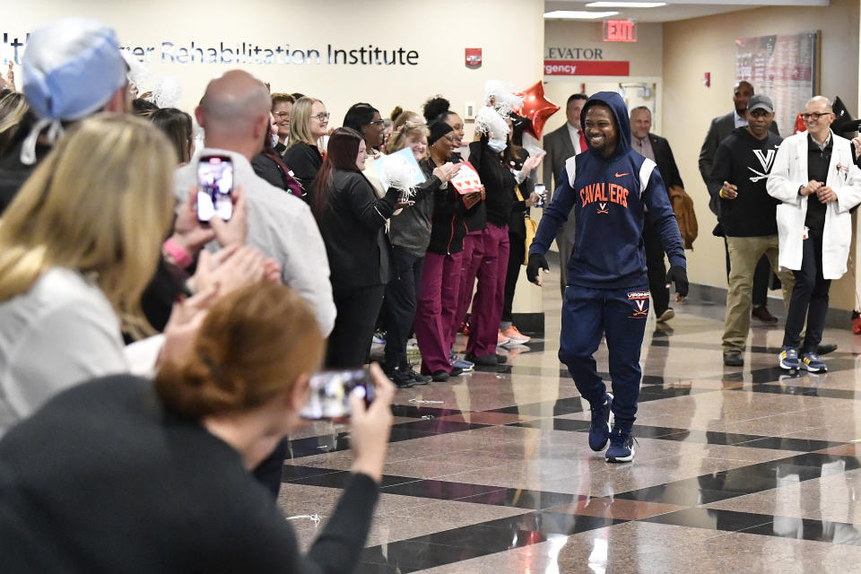 Perris Jones, center, is cheered by supporters and staff as he is discharged from Frazier Rehabilitation Institute in Louisville, Ky., Tuesday, Nov. 28, 2023. Jones, a player on the University of Virginia football team was injured during a game against Louisville on Nov. 9th, and after two and a half weeks is being discharged. (AP Photo/Timothy D. Easley)