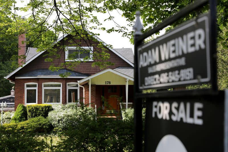 FILE PHOTO: A realtor's sign stands outside a house for sale in Toronto