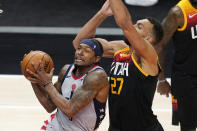 Washington Wizards guard Bradley Beal, left, goes to the basket as Utah Jazz center Rudy Gobert (27) defends in the first half during an NBA basketball game Monday, April 12, 2021, in Salt Lake City. (AP Photo/Rick Bowmer)