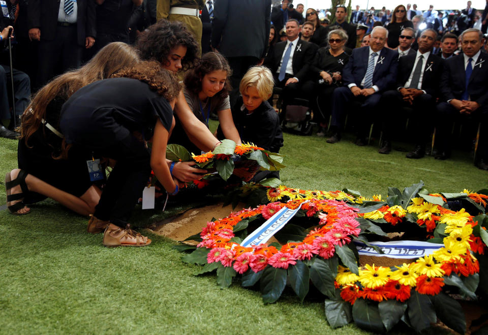 <p>Grandchildren of former Israeli President Shimon Peres lay a wreath on the grave of their grandfather during the burial ceremony at Mount Herzl Cemetery in Jerusalem on Sept. 30, 2016. (REUTERS/Ronen Zvulun) </p>