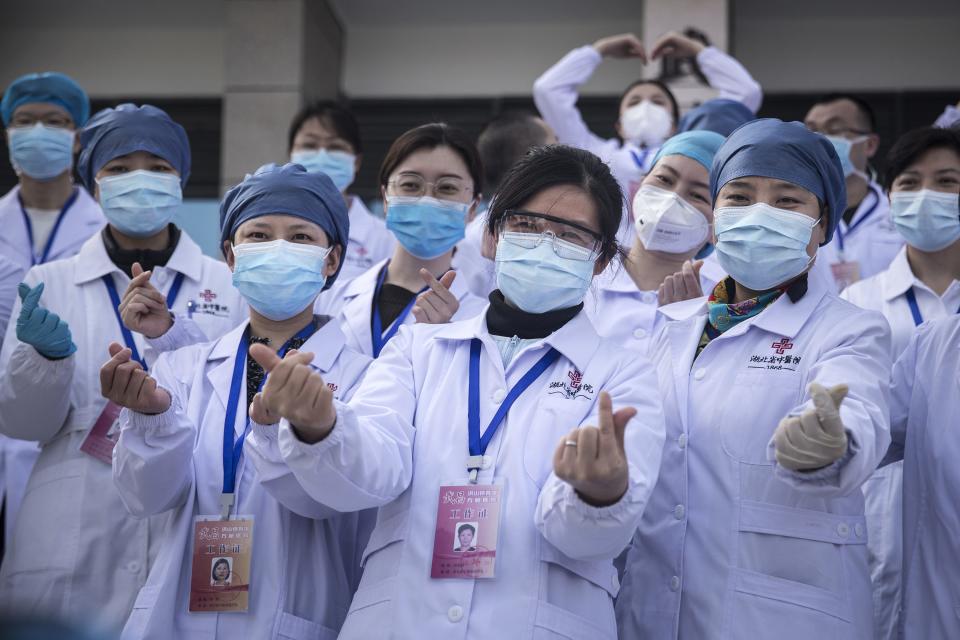 Medical professionals celebrate in Wuhan, China, as the last batch of COVID-19 patients are discharged from a makeshift hospital on March 10, 2020.