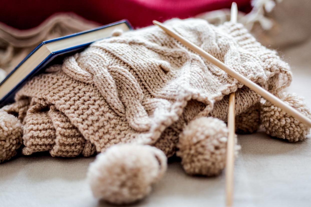 wooden knitting needles and book