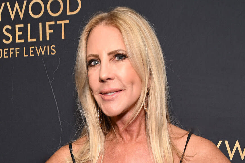 Vicki Gunvalson smiling in front of a step and repeat.