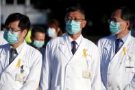 Doctors wearing yellow ribbons in memory of former Taiwan President Lee look at a hearse carrying the casket of the late president in Taipei