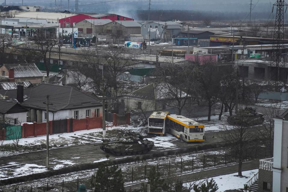 FILE- Russian army tanks move through a street on the outskirts of Mariupol, Ukraine, March 11, 2022. Associated Press photographer Evgeniy Maloletka won the World Press Photo Europe Stories Award with this image which was part of a series of images titled The Siege of Mariupol, and won the World Press Photo of the Year award on Thursday, April 20, 2023, for his harrowing image of emergency workers carrying a pregnant woman through the shattered grounds of a maternity hospital in the Ukrainian city of Mariupol in the chaotic aftermath of a Russian attack.