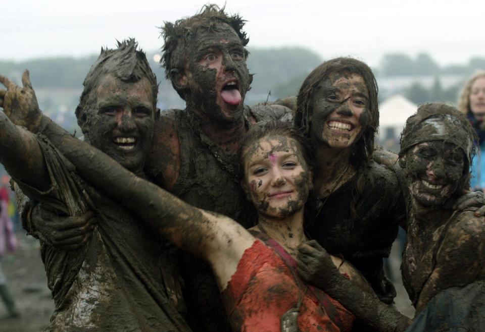 Festival-goers dance in the mud in front of the Pyramid stage in 2004 (Getty Images)