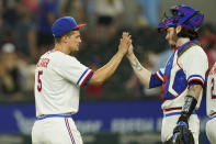 Texas Rangers shortstop Corey Seager (5) is congratulated by catcher Jonah Heim after the final out of the team's baseball game against the Seattle Mariners in Arlington, Texas, Saturday, Aug. 13, 2022. The Rangers won 7-4. (AP Photo/LM Otero)