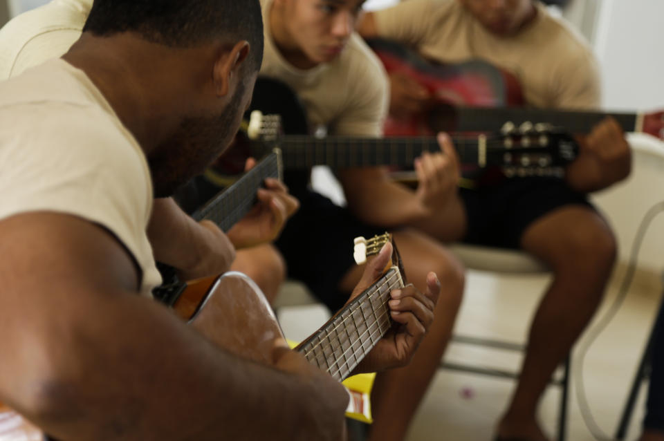 A group of young inmates play guitars during choir practice at the Las Garzas de Pacora detention center, Panama, Wednesday, Jan. 16, 2019. The group rehearsed the World Youth Day hymn at the entrance to the school. One boy played the piano, others strummed guitars and still others formed the chorus, coached by volunteers ahead of a planned performance for the pontiff. (AP Photo/Arnulfo Franco)