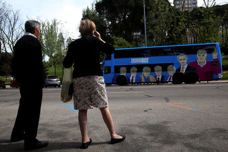 People look at a bus sponsored by Podemos (We can) party painted with pictures representing Spain's recent political scandals as it tours Madrid, Spain April 18, 2017. Picture taken April 18, 2017. REUTERS/Susana Vera