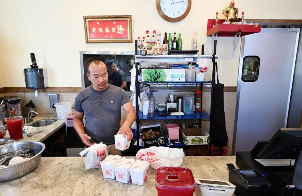 El propietario y chef Yongwei Huang prepara un pedido de comida en el restaurante Lucky House de Riverbank, California, el jueves 27 de junio de 2024.