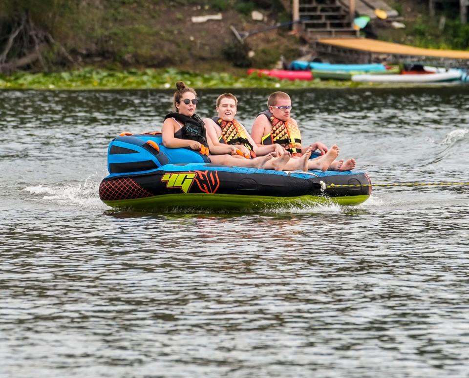 Vince, center, and Samuel Christi of Pewaukee, enjoy tubing volunteer Emily Sodolski during the 2022 At The Lake event at Camp Whitcomb/Mason in Hartland on Friday, August 19. The free annual two-day event is designed to give individuals with disabilities or special needs the chance to experience a variety of activities on the water. Trained instructors and safety personnel assist attendees as they try waterskiing, wakeboarding, tubing, kayaking, pontooning, fishing and a host of fun-filled shoreline activities.