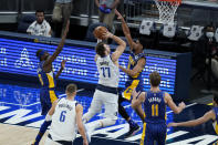 Dallas Mavericks' Luka Doncic (77) puts up a shot against Indiana Pacers' Jeremy Lamb (26) during the first half of an NBA basketball game, Wednesday, Jan. 20, 2021, in Indianapolis. (AP Photo/Darron Cummings)