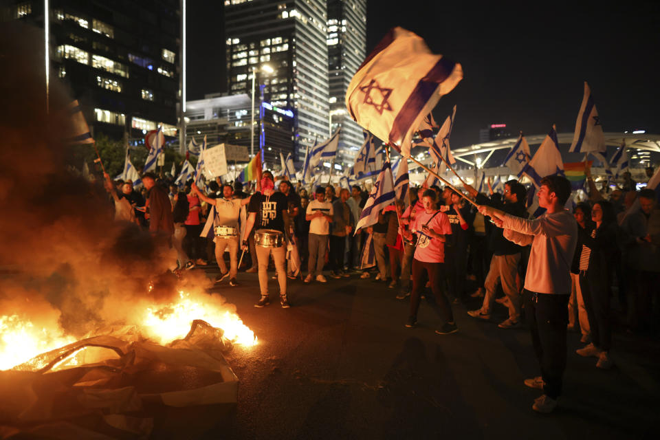 Israelis opposed to Prime Minister Benjamin Netanyahu's judicial overhaul plan set up bonfires and block a highway during a protest moments after the Israeli leader fired his defense minister, in Tel Aviv, Israel, Sunday, March 26, 2023. Defense Minister Yoav Gallant had called on Netanyahu to freeze the plan, citing deep divisions in the country and turmoil in the military. (AP Photo/Oren Ziv)