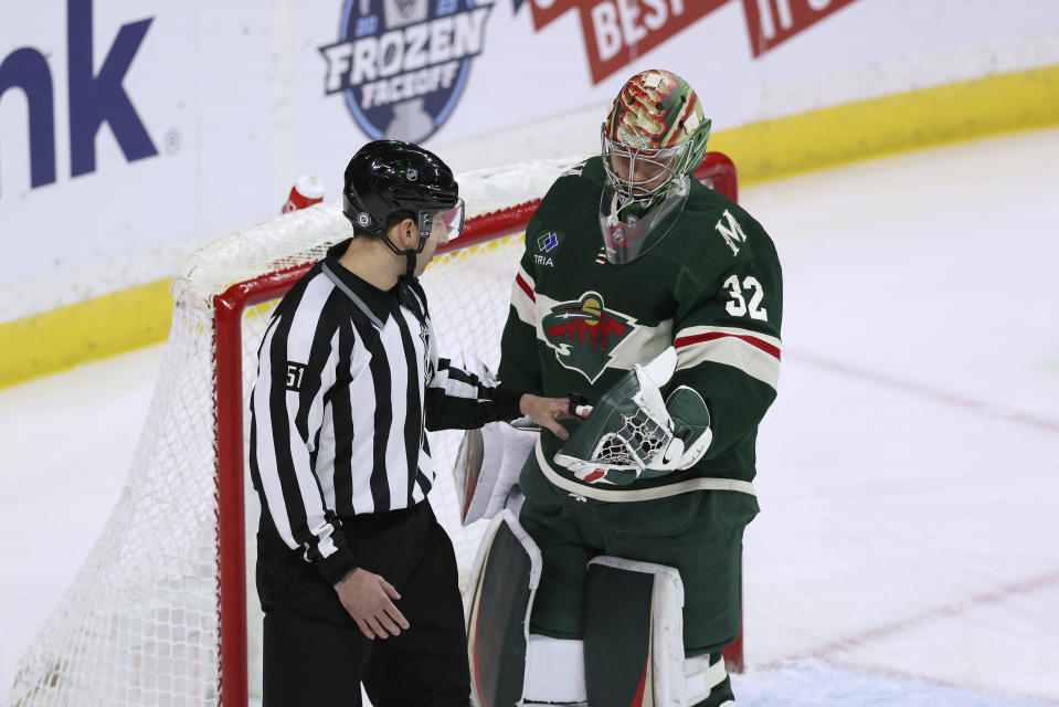 Minnesota Wild goaltender Filip Gustavsson (32) hands off the puck after a save against the Calgary Flames during the first period of an NHL hockey game Tuesday, March 7, 2023, in St. Paul, Minn. (AP Photo/Stacy Bengs)