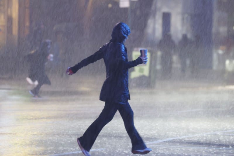 A pedestrian hustles across Seventh Avenue as heavy rain falls in Times Square in New York City on Monday. Heavy rain and gusty winds battered New York City overnight Monday, leaving thousands of residents without power. Photo by John Angelillo/UPI