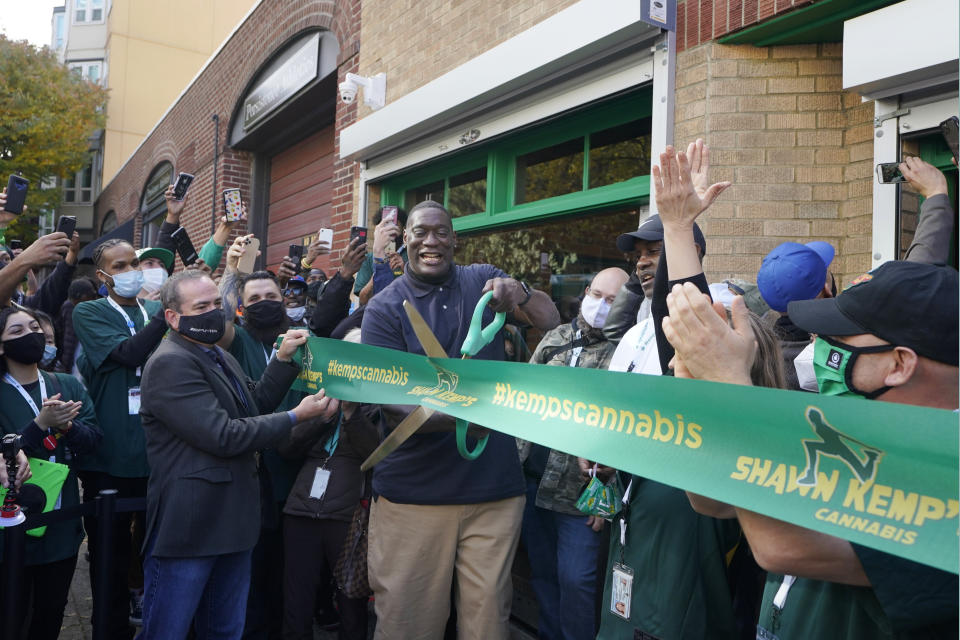 Shawn Kemp, center, a former NBA basketball player for the Seattle SuperSonics and several other teams, cuts the grand-opening ribbon for Shawn Kemp's Cannabis, the marijuana dispensary he owns with several business partners, Friday, Oct. 30, 2020, in downtown Seattle. (AP Photo/Ted S. Warren)