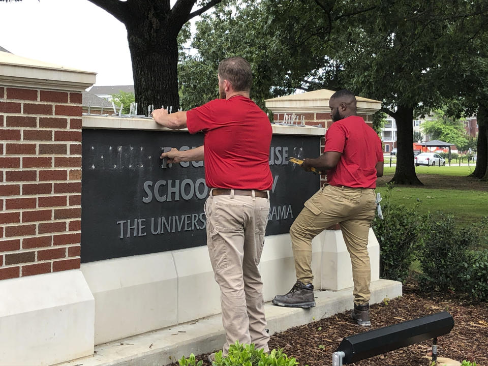 University of Alabama employees remove the name of Hugh F. Culverhouse Jr. off the School of Law sign in Tuscaloosa, Ala., Friday, June 7, 2019. The University of Alabama board of trustees voted Friday to give back a $26.5 million donation to a philanthropist Hugh F. Culverhouse Jr., who recently called on students to boycott the school over the state's new abortion ban. (AP Photo/Blake Paterson)