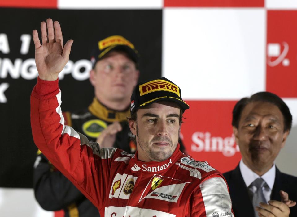 Ferrari Formula One driver Fernando Alonso of Spain waves on the podium after the Singapore F1 Grand Prix at the Marina Bay street circuit in Singapore September 22, 2013. REUTERS/Pablo Sanchez (SINGAPORE - Tags: SPORT MOTORSPORT F1)