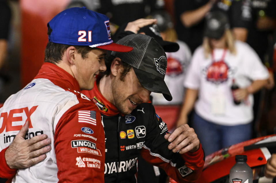 Ryan Blaney, right, is embraced in Victory Lane by Harrison Burton after winning a NASCAR Cup Series auto race at Charlotte Motor Speedway, Monday, May 29, 2023, in Concord, N.C. (AP Photo/Matt Kelley)