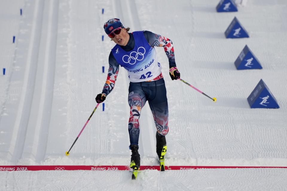 Johannes Hoesflot Klaebo, of Norway, crosses the finish line during the men's 15km classic cross-country skiing competition at the 2022 Winter Olympics, Friday, Feb. 11, 2022, in Zhangjiakou, China. (AP Photo/Aaron Favila)
