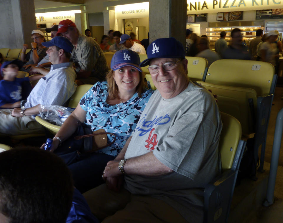 Michelle Pepe junto a su padre Bernie Rubin en una foto de julio del 2010, durante un partido de los Dodgers en Los Ángeles. Pepe cree que contagió el COVID-19 a su padre, quien falleció, y vive atormentada por ello. (Bob Pepe via AP).