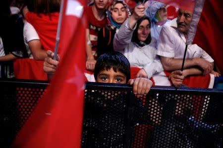 A young boy holds a Turkish national flag as supporters of Turkish President Tayyip Erdogan attend a pro-government demonstration on Taksim square in Istanbul, Turkey, July 20, 2016. REUTERS/Alkis Konstantinidis