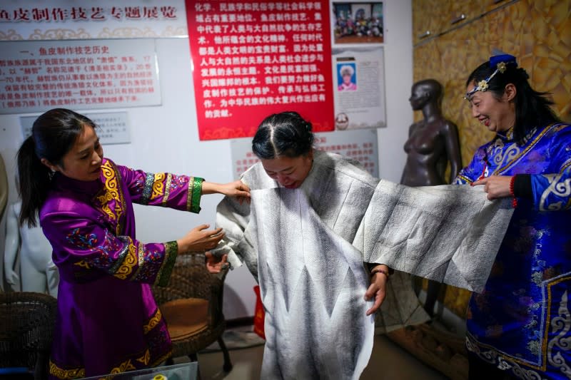 ethnic Hezhen You Wenfeng's Chinese Han students learn how to make clothes from fish skin at You's studio in Tongjiang