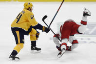 Carolina Hurricanes right wing Sebastian Aho (20) falls to the ice after colliding with Nashville Predators center Mikael Granlund (64) during the the third period of an NHL hockey game Saturday, May 8, 2021, in Nashville, Tenn. (AP Photo/Mark Zaleski)